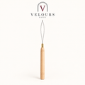 Un tire-mèche à boucle et manche en bois, logo Velours Hair